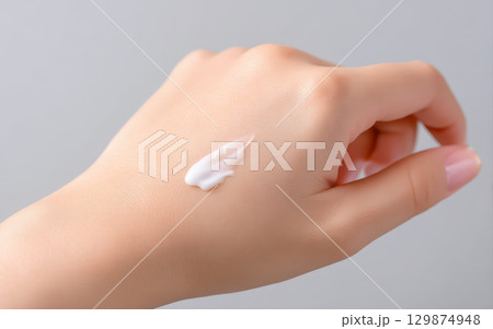 Makeup foundation blending on hand skin close up shows beauty cosmetic routine for face makeup application with smooth texture and natural tone enhancing healthy look 129874948