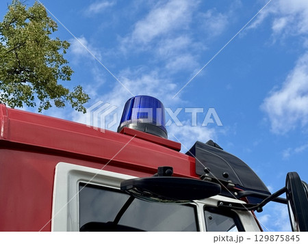 A red fire truck equipped with an emergency siren on a summer day. High quality photo 129875845