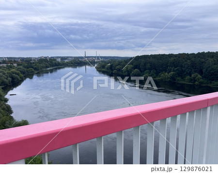The early Spring view of the pedestrian bridge leading to Neman River beach and the biggest park in Kaunas city (Lithuania). The early Spring view of the pedestrian bridge leading to Neman River beach and the biggest park in Kaunas city (Lithuania). 129876021