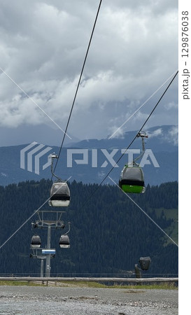 Scenic Mountain Cable Cars Gliding Above Forested Hills 129876038