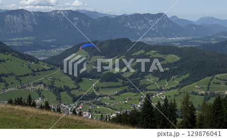 Paraglider Soaring Over Alpine Valley Landscape 129876041