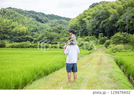肩車、父と息子の後ろ姿　夏休み田舎　 129876602