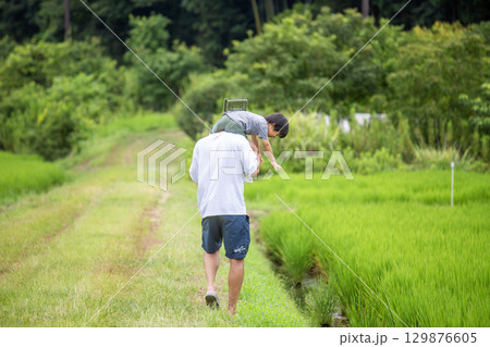 肩車、父と息子の後ろ姿　夏休み田舎　 129876605