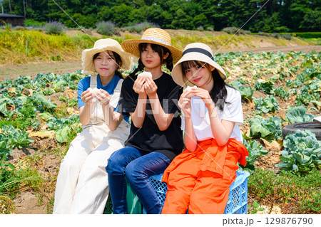 夏の高原で麦わら帽子をかぶった日本人の女の子たちが白いおにぎりを持って座る 夏の高原で麦わら帽子をかぶった日本人の女の子たちが白いおにぎりを持って座る 129876790
