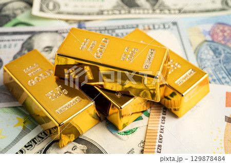 Gold bars on US dollar banknote money, finance trading investment business currency. 129878484