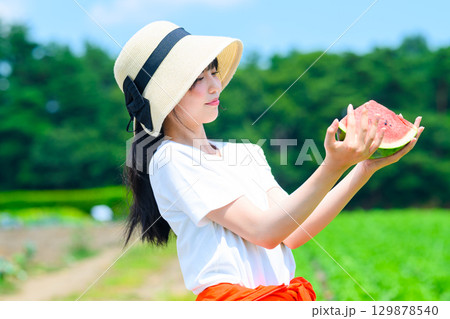 夏の高原で麦わら帽子をかぶった小学生の女の子がスイカを持つ風景 夏の高原で麦わら帽子をかぶった小学生の女の子がスイカを持つ風景 129878540