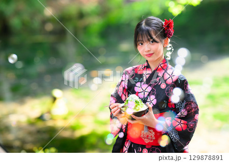 高原の湖で浴衣を着た日本人の小学生の女の子がかき氷を食べている風景 129878891