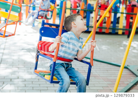 boy riding on an amusement swing 129879333