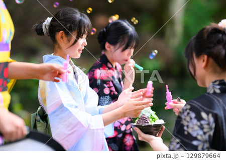 浴衣を着た日本人の小学生の女の子がシャボン玉で遊ぶ夏の風景 浴衣を着た日本人の小学生の女の子がシャボン玉で遊ぶ夏の風景 129879664