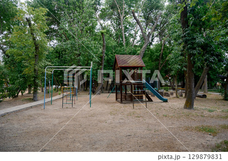 Children's playground with a view of the house and slide in the park 129879831