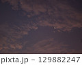 Minimalist view of a crescent moon surrounded by textured clouds at twilight. The soft gradient sky creates a calm, atmospheric mood with copy space. 129882247