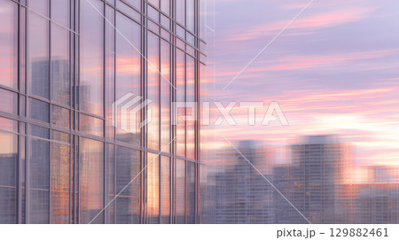 Urban landscape glows with pink and orange hues as buildings reflect a tranquil summer sunset. 129882461
