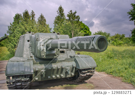 An old tank against the backdrop of summer nature and a dramatic sky 129883271