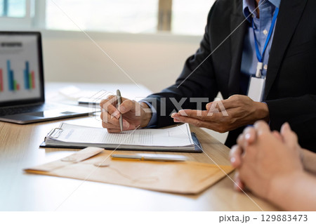 Insurance Consultation. Businessman discussing policy details with client in office. 129883473
