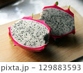 Dragon fruit, pitaya, pitahaya on a wooden board on a white background. Exotic fruit cut in half. White pulp with seeds. Cactus fruit 129883593