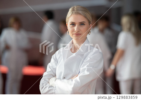Young female doctor posing in front of medical staff 129883859