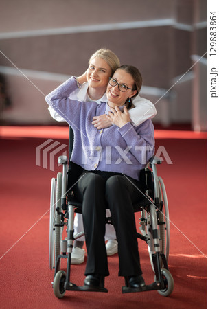 Young nurse hugging elderly woman in wheelchair 129883864