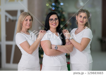 Group of smiling nurses walking in hospital hallway Group of smiling nurses walking in hospital hallway 129883883