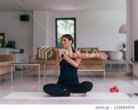 Young Beautiful Female Exercising, Stretching and Practising Yoga with Trainer via Video Call Conference in Bright Sunny House. Healthy Lifestyle, Wellbeing and Mindfulness Concept. Young Beautiful Female Exercising, Stretching and Practising Yoga with Trainer via Video Call Conference in Bright Sunny House. Healthy Lifestyle, Wellbeing and Mindfulness Concept. 129884074