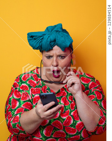 Surprised plus-size woman looking at smartphone with wide expression Surprised plus-size woman looking at smartphone with wide expression 129884514
