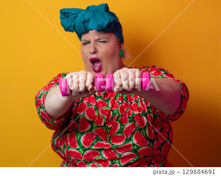 Funny plus size woman lifting dumbbells in watermelon dress Funny plus size woman lifting dumbbells in watermelon dress 129884691
