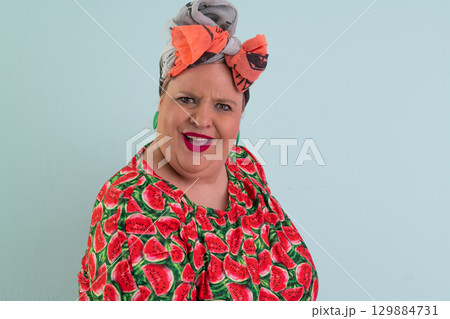 Unimpressed woman in watermelon dress posing with hands on hips 129884731