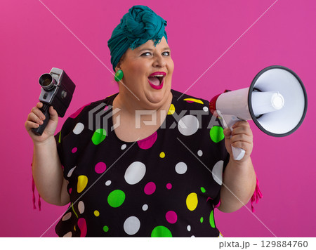 Shouting woman holding megaphone and vintage camera 129884760