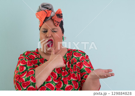 Surprised woman pointing at open hand in studio Surprised woman pointing at open hand in studio 129884828