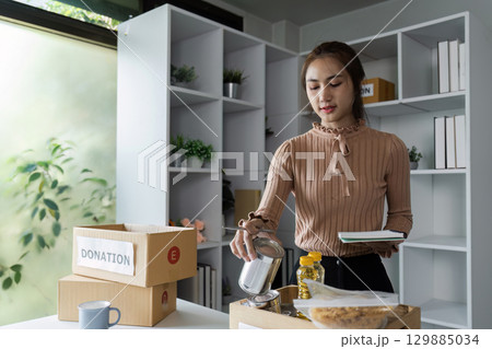 Volunteers Organizing Supplies at Donation Centers and Food Banks to Support Communities in Need 129885034