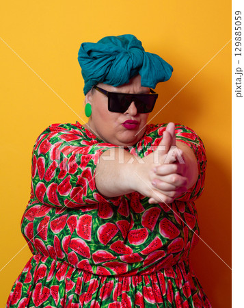 Funny plus size woman making finger gun pose in sunglasses Funny plus size woman making finger gun pose in sunglasses 129885059