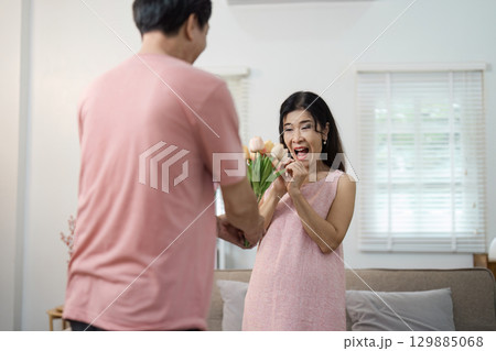Joyful Senior Couple Celebrating Valentine's Day with Flowers at Home in a Cozy Living Room Setting Joyful Senior Couple Celebrating Valentine's Day with Flowers at Home in a Cozy Living Room Setting 129885068