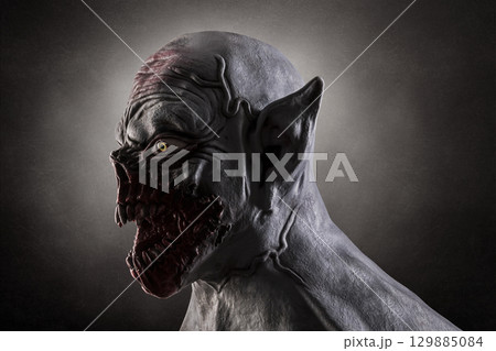 Portrait of a monster with sharp fangs over dark foggy background. Silicone mask was used in this photo. Portrait of a monster with sharp fangs over dark foggy background. Silicone mask was used in this photo. 129885084