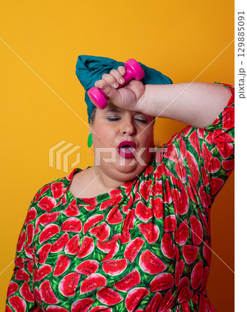 Exhausted plus size woman resting after dumbbell workout Exhausted plus size woman resting after dumbbell workout 129885091