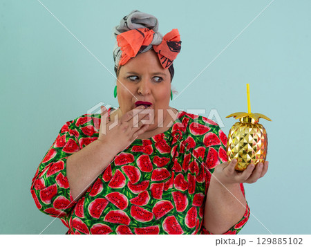 Playful Woman with Golden Pineapple Cup Wearing Watermelon Dress Playful Woman with Golden Pineapple Cup Wearing Watermelon Dress 129885102