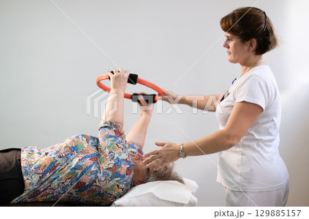 Physiotherapy Session with Elderly Woman Using Exercise Ring 129885157