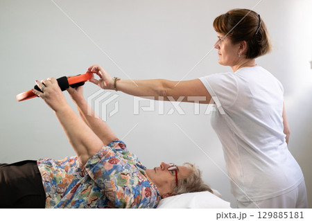 Physiotherapy Session with Elderly Woman Using Exercise Ring 129885181