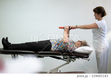 Physiotherapy Session with Elderly Woman Using Exercise Ring 129885183