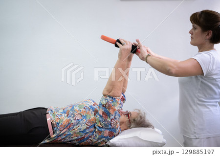 Physiotherapy Session with Elderly Woman Using Exercise Ring 129885197