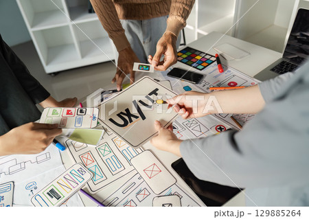 Creative UX UI Design Brainstorming Session with Designers Collaborating on Innovative Ideas and Wireframes 129885264