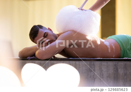 Foam Massage Session.Hamam attendant applying foam massage on patient back with circular motions. 129885623