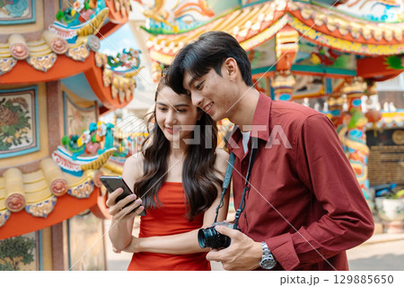 Joyful Travelers Celebrating Chinese New Year at a Vibrant Temple with Traditional Decorations and Festive Atmosphere Joyful Travelers Celebrating Chinese New Year at a Vibrant Temple with Traditional Decorations and Festive Atmosphere 129885650