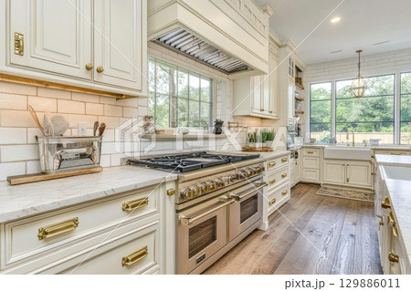 A large kitchen with a white stove and oven, and a window above it 129886011