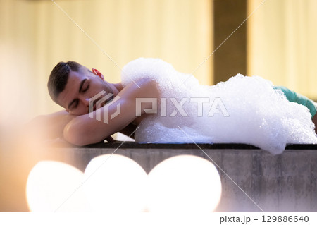 Man Relaxing in Foam.Relaxed man lying in Turkish bath covered in white foam during cleansing ritual. Man Relaxing in Foam.Relaxed man lying in Turkish bath covered in white foam during cleansing ritual. 129886640