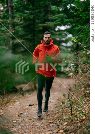 Jogger in Autumn Forest Trail Jogger in Autumn Forest Trail 129886840