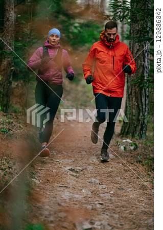 Happy Couple Running on a Forest Trail Happy Couple Running on a Forest Trail 129886842