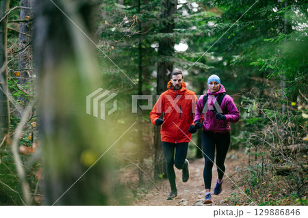Happy Couple Running on a Forest Trail Happy Couple Running on a Forest Trail 129886846