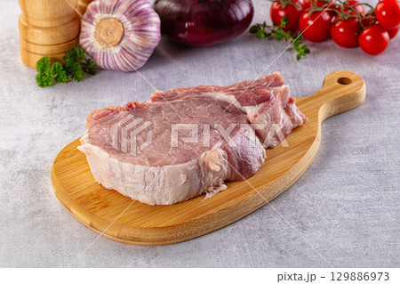 Raw pork steak with bone 129886973