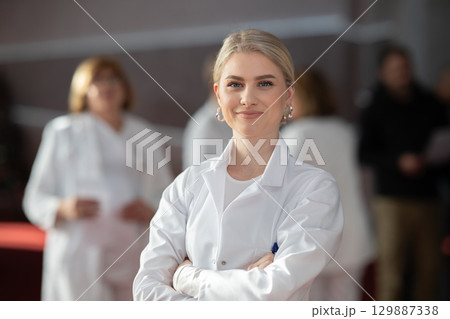 Young female doctor posing in front of medical staff 129887338