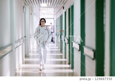 Doctor smiling in hospital hallway 129887350