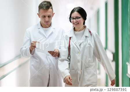 Doctors Walking in Hospital Hallway 129887391